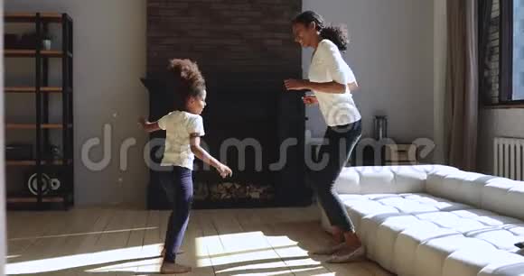 非洲小女孩和年轻的妈妈一起拍手跳舞视频的预览图
