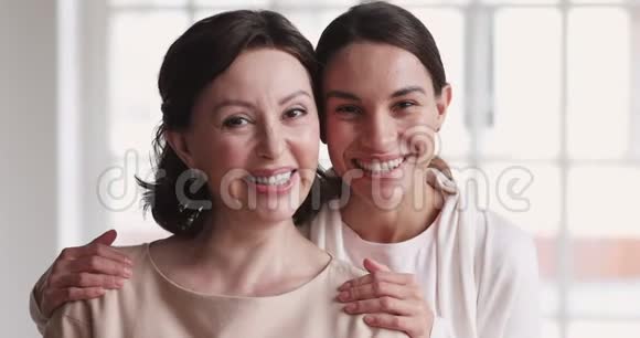 快乐成熟的妈妈和年轻的女儿拥抱欢笑肖像视频的预览图