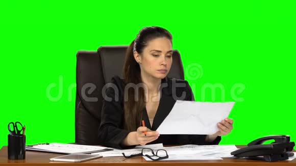 商务女性坐在皮椅上阅读文件并做笔记绿色屏幕工作室视频的预览图