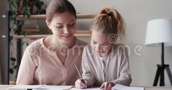 快乐的小妈妈帮可爱的小女儿做作业视频的预览图