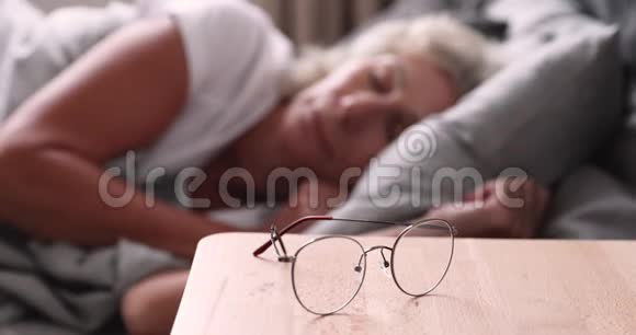 早上醒来的老妇人戴着光学眼镜视频的预览图