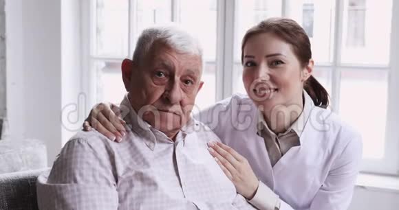 关爱微笑的女性照顾者拥抱快乐的老年患者特写肖像视频的预览图