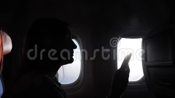 在飞机上女孩坐着智能手机靠窗视频的预览图
