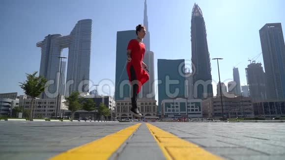 年轻女孩跳着跳绳以迪拜为背景动作缓慢视频的预览图