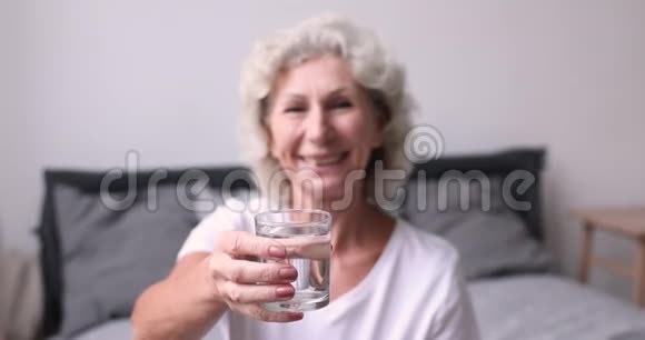 健康快乐的老年妇女推荐新鲜的矿泉水视频的预览图