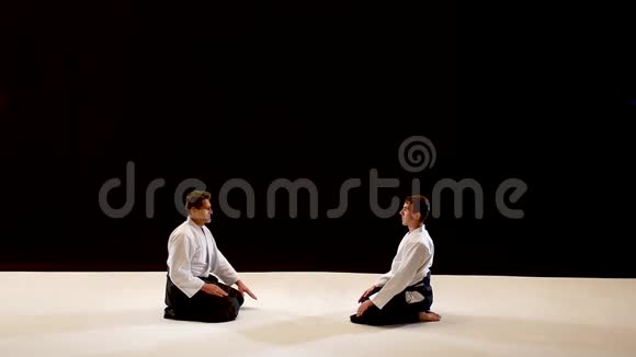 两个大师武术合气道互相鞠躬拍摄在黑白背景上慢动作视频的预览图