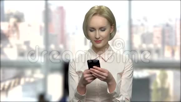微笑的女人在她的智能手机上输入信息视频的预览图