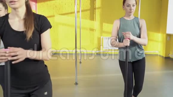 在健身室和教练一起做普拉提运动的年轻女性视频的预览图