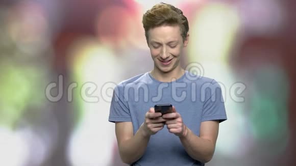 微笑的欧洲男孩使用智能手机视频的预览图