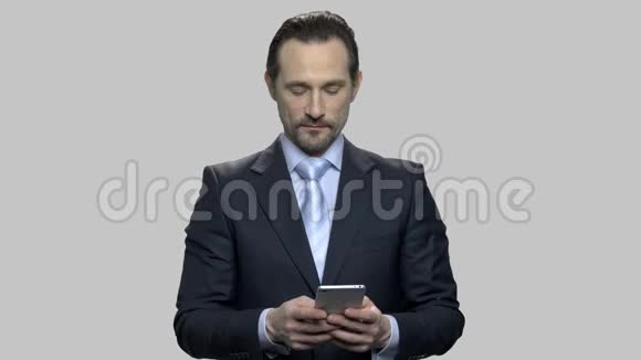 自信的商人在他的智能手机上输入信息视频的预览图