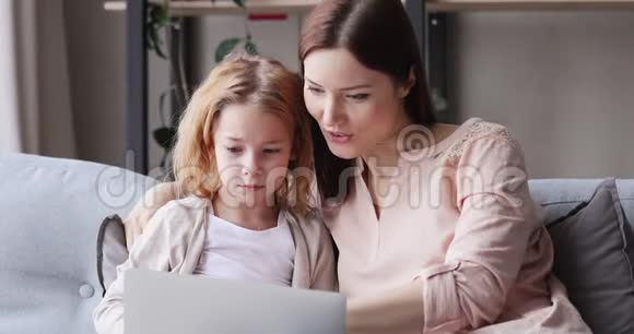 令人兴奋的母亲和女儿看着笔记本电脑屏幕感觉赢家视频的预览图