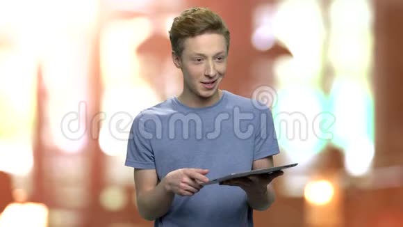 十几岁的男孩一边拿着电脑平板电脑说话视频的预览图