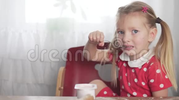 一个小女孩在家里厨房里吃奶酪视频的预览图