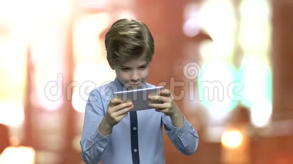 兴奋的男孩在手机上玩游戏视频的预览图