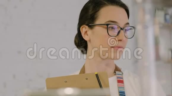 戴眼镜的女人写剪贴板视频的预览图