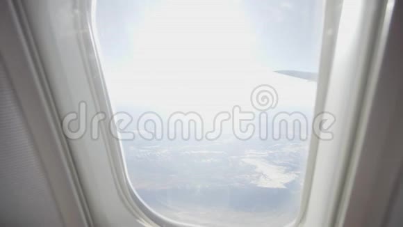 快乐的年轻女子在阳光下从飞机的窗户看着视频的预览图