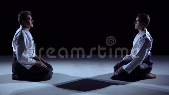 两个大师武术合气道互相鞠躬拍摄在黑白背景上慢动作快关门视频的预览图