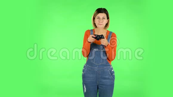 女孩玩电子游戏使用无线控制器喜悦和喜悦的胜利绿色屏幕视频的预览图