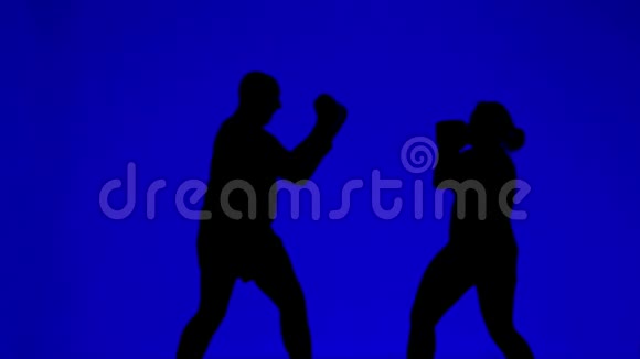 战斗训练中戴拳击手套的男女剪影视频的预览图
