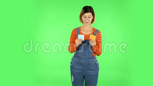 女孩拿着纸棒表达糟糕的心情然后采取另一种表达好心情绿色屏幕视频的预览图