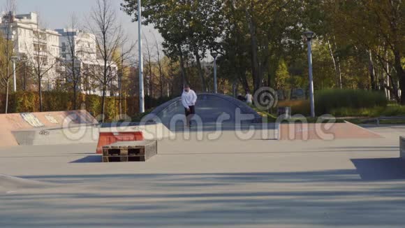 秋日滑板运动员在滑板公园玩滑板视频的预览图