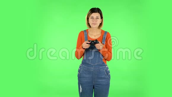 女孩玩电子游戏使用无线控制器与喜悦和失败绿色屏幕视频的预览图