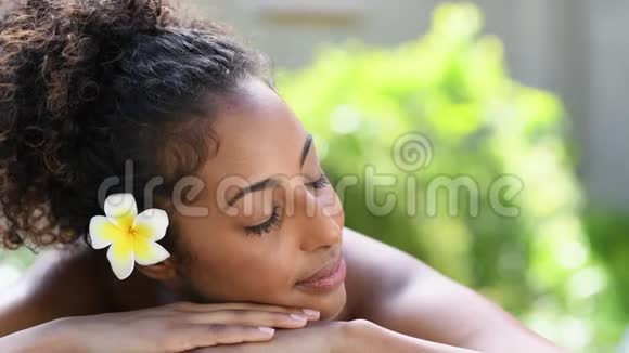 美丽的非洲女人躺在温泉按摩台上视频的预览图