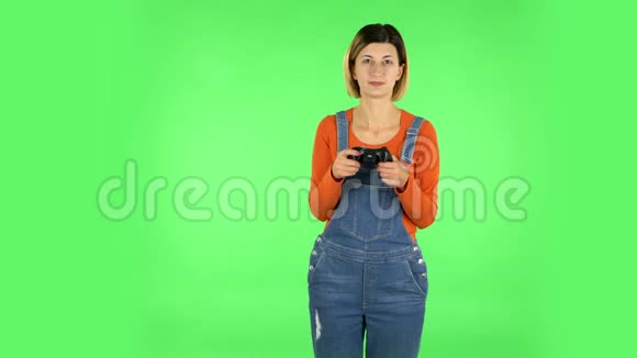 女孩玩电子游戏使用无线控制器与喜悦和哇的情绪绿色屏幕视频的预览图