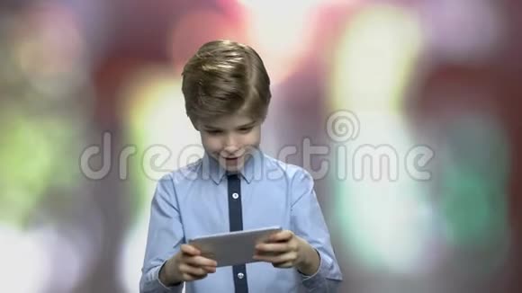 小男孩在智能手机上玩网络游戏视频的预览图