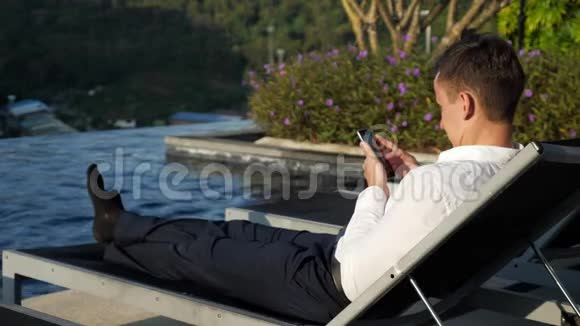 一个人在泳池边靠着一把折叠椅视频的预览图