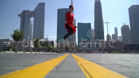 年轻女孩跳着跳绳以迪拜为背景动作缓慢视频的预览图