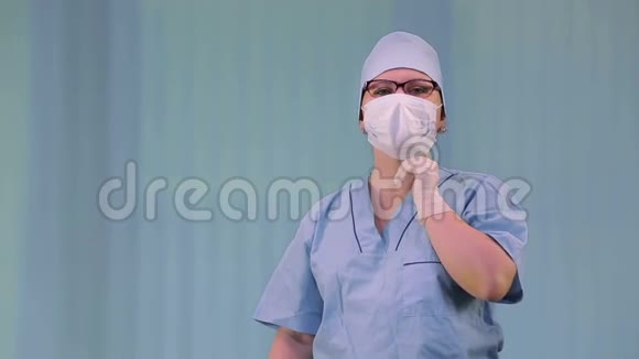 戴着医用口罩的女医生一边用戴手套的手藏起来一边咳嗽视频的预览图