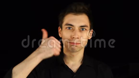 蓝眼睛的黑衣人在黑色背景上竖起大拇指视频的预览图