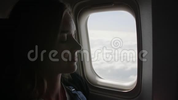 一个年轻的女人睡在飞机的窗户上视频的预览图