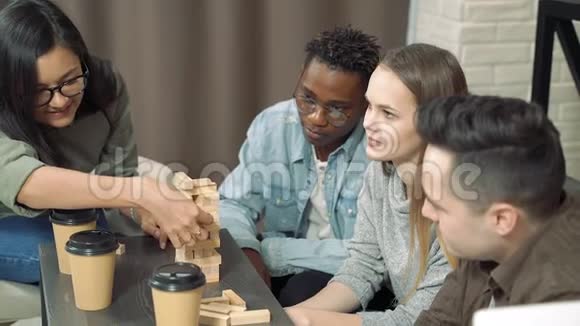 一群快乐的朋友在客厅里玩积木移除游戏给五个视频的预览图