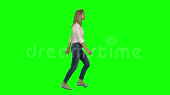 金发女人在绿色的屏幕上微笑着奔跑铬钥匙4k射击侧写视图视频的预览图