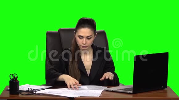 穿着紧身的女性阅读文件划掉所写的东西把皱巴巴的纸从桌子上扔掉绿色屏幕视频的预览图