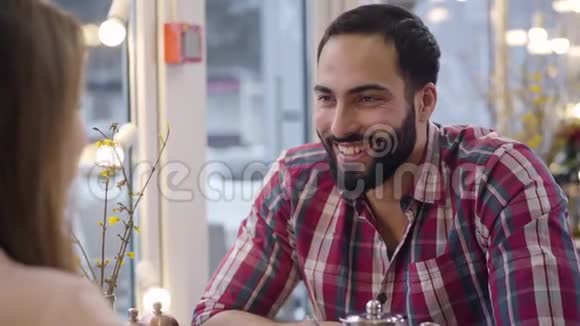 正面的中东留着胡子的男人在嘲笑他面目全非的高加索女朋友时大声笑出来的画像视频的预览图