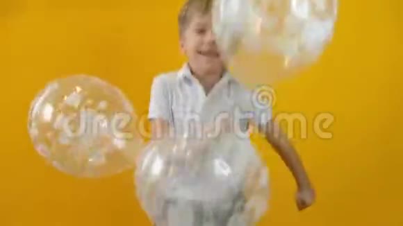 快乐的小男孩蹒跚学步的孩子在孤立的黄色背景下与蝴蝶结跳舞视频的预览图