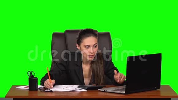 商务女性在笔记本电脑上工作将数据与计算器上的计数进行比较并在文档中输入绿色视频的预览图