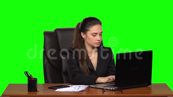 在笔记本电脑上工作的女人然后用手机接电话看文件时很惊讶很高兴绿色视频的预览图