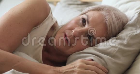 厌倦的成熟女人感到沮丧在床上失眠视频的预览图