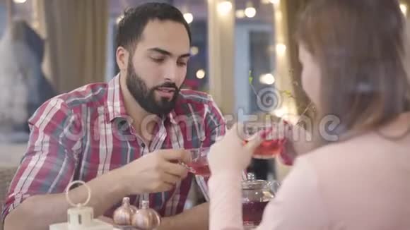 愤怒的中东男人在咖啡馆里与高加索女朋友争吵的肖像惹怒了年轻英俊的男朋友视频的预览图