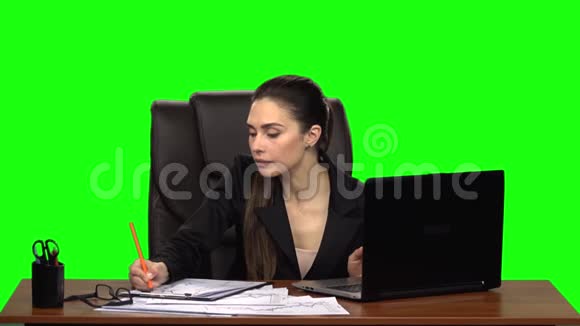 女经理在笔记本电脑上工作思考做笔记然后微笑与快乐绿色屏幕背景慢动作视频的预览图