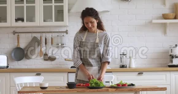 可爱的年轻迷人的女人切新鲜蔬菜做沙拉视频的预览图