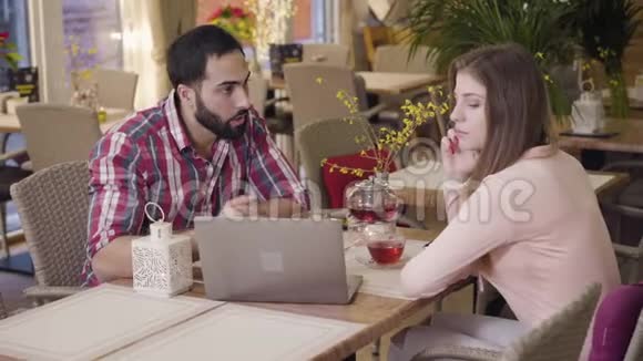年轻的高加索女人和中东男人在咖啡馆吃商务午餐的肖像成功人士视频的预览图