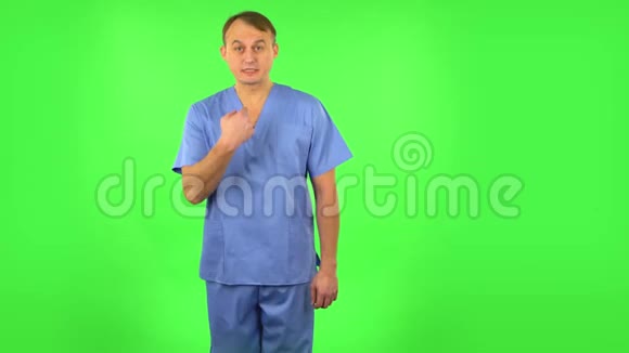 医务人员举起双手表示自己是无辜的用手指扭过他的太阳穴绿色屏幕视频的预览图