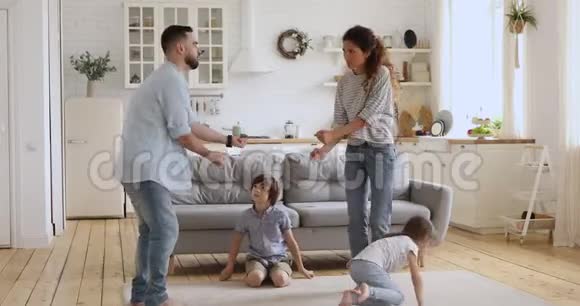 快乐无忧无虑的一对夫妇和两个小孩子一起跳舞视频的预览图