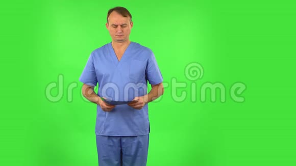 男医生穿着蓝色外套用x光检查快照解释并显示拇指样绿色屏幕视频的预览图