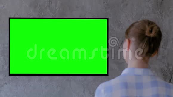 绿色屏幕概念女性观看绿色显示器的平板智能LED电视视频的预览图